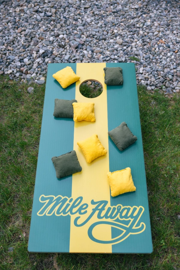 Mile Away branded cornhole board set up on the grass